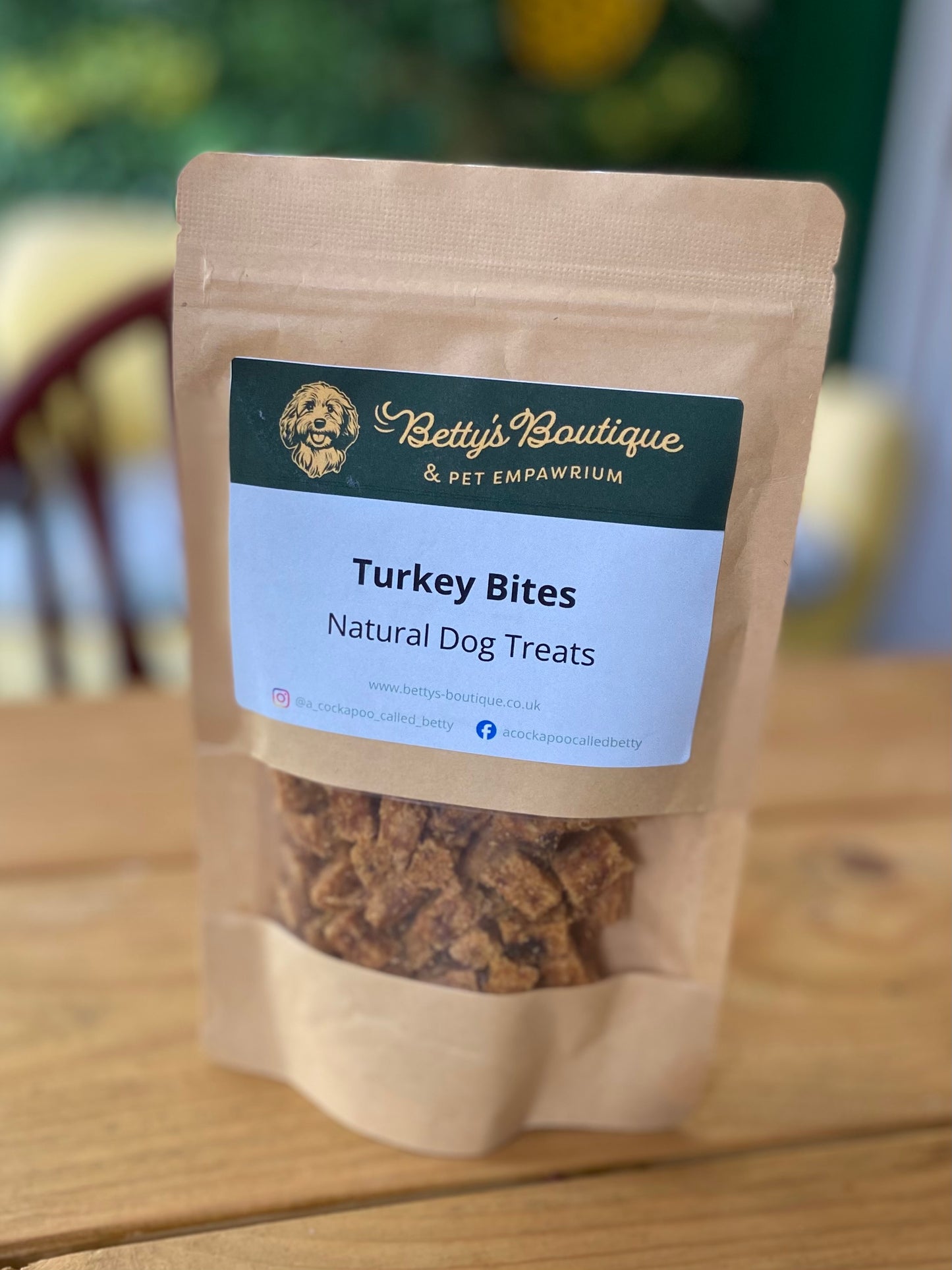 Package of Betty's Boutique Turkey Bites natural dog treats on a wooden surface.