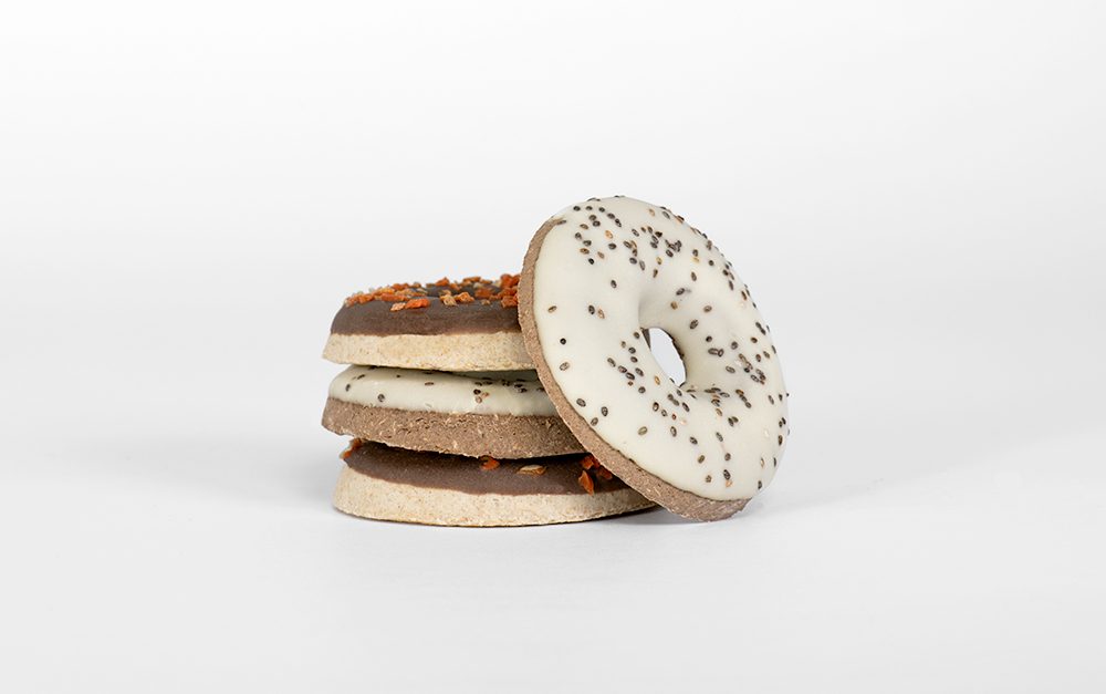 Stack of cookies with white and chocolate icing on a light gray background
