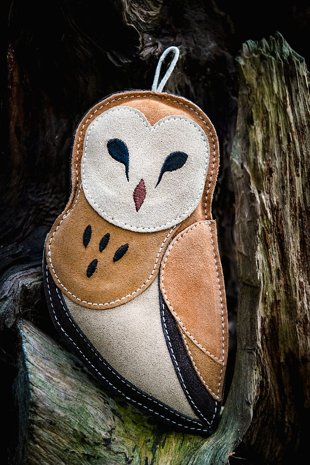 suede owl dog toy in a tree