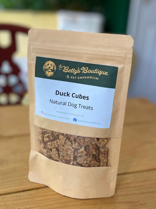 Package of Betty's Boutique Duck Cubes natural dog treats on a wooden surface