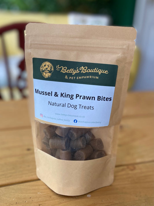 Bag of Mussel & King Prawn Bites natural dog treats from Betty's Boutique on a wooden surface.