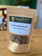 Package of Betty's Boutique Pork & Apple Bones natural dog treats on a wooden surface.