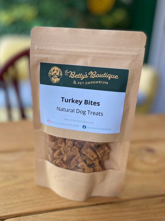 Package of Betty's Boutique Turkey Bites natural dog treats on a wooden surface.