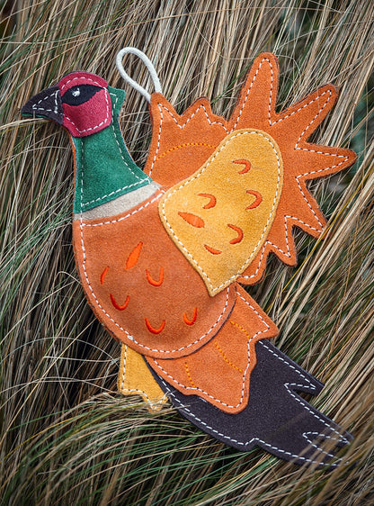 suede pheasant dog toy in grass