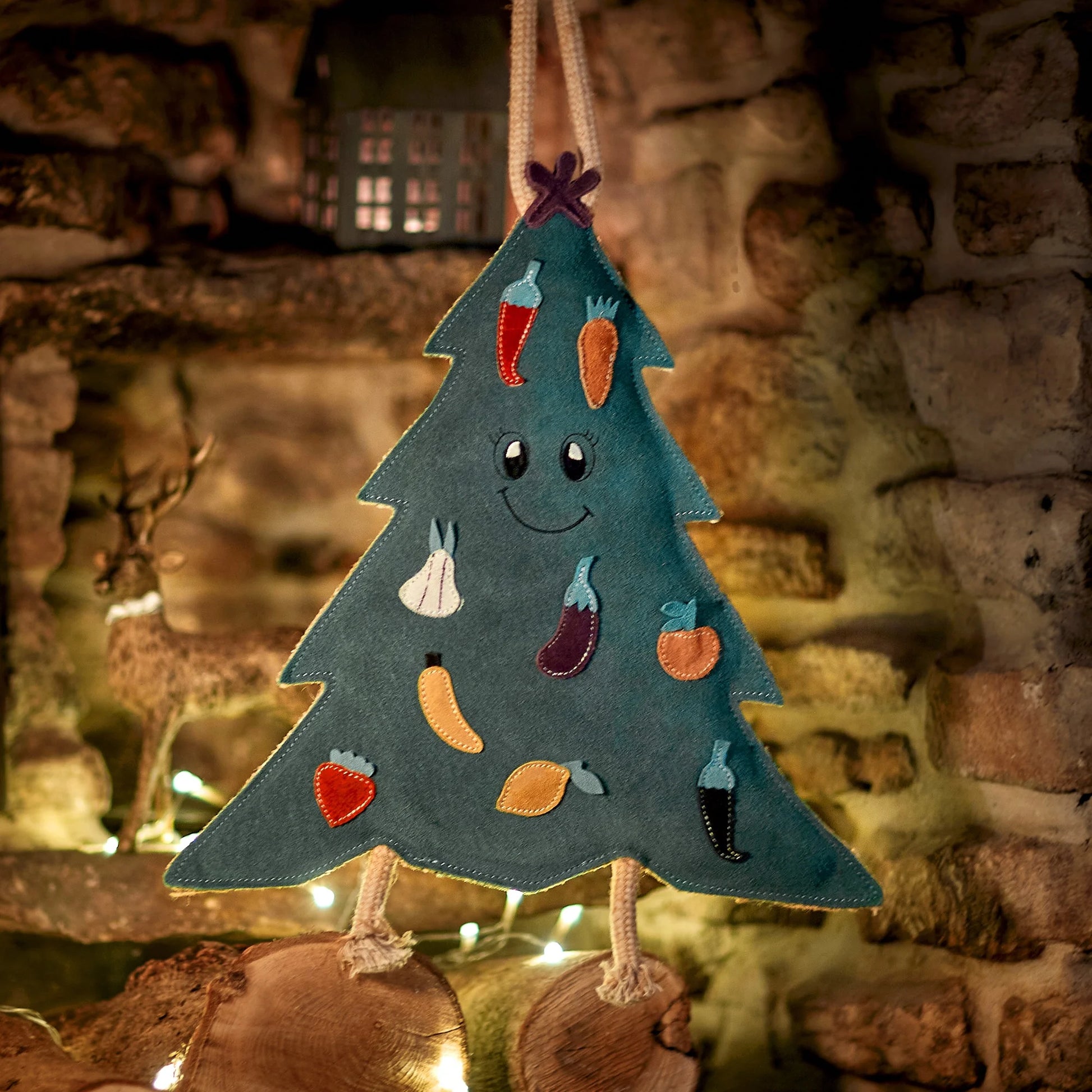 Decorative Christmas tree dog toy with vegetables on a stone fireplace background