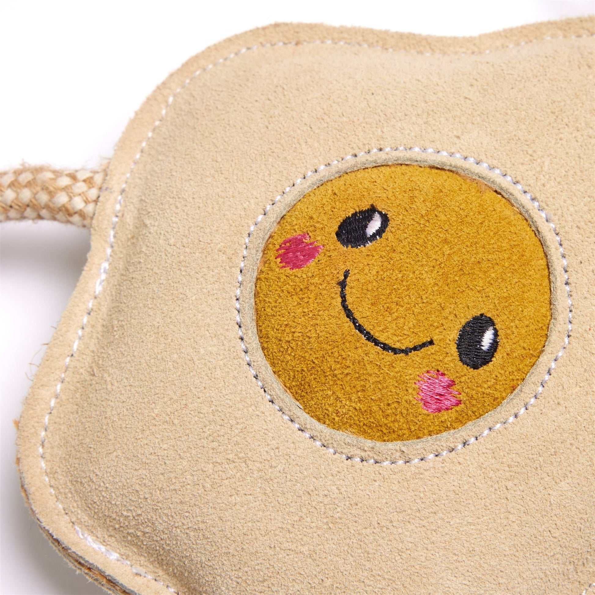 Beige dog toy with a smiley face design on a white background
