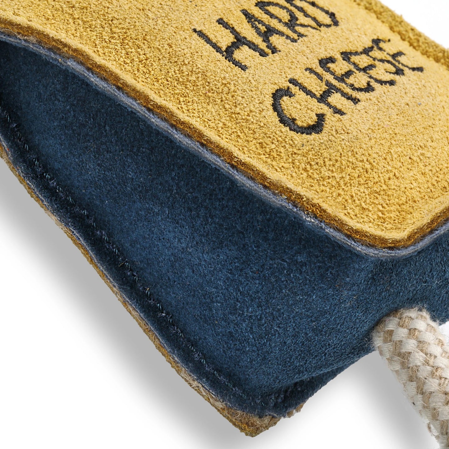 Dog chew toy with 'Hard Cheese' text on a blue and yellow surface