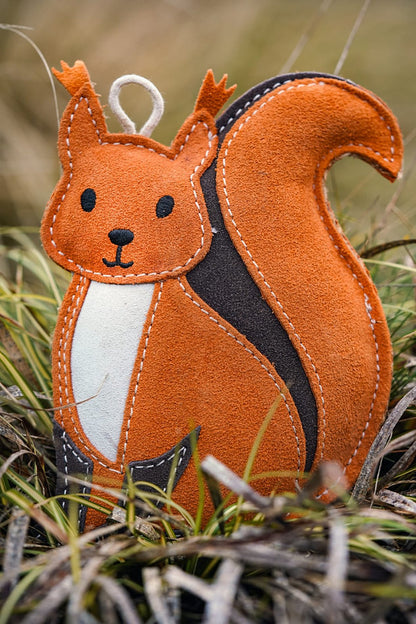 suede squirrel dog toy in grass