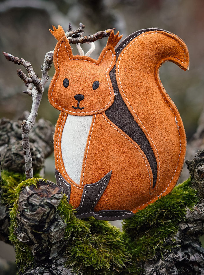 suede squirrel dog toy in woods