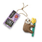 Cat toy shaped like a sloth holding a yellow flower with a 'Green & Wilds' label on a white background